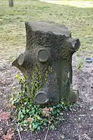 Unconventional tombstone in the Cemetery Park of the "Freireligiöse Gemeinde" in Berlin, Prenzlauer Berg. Tree stump headstones in U.S. cemeteries are often associated with fraternal organization Woodmen of the World