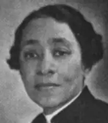 A Black woman with short hair, wearing a suit