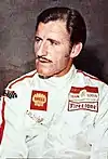 Graham Hill in a racing suit looking to the right of the camera