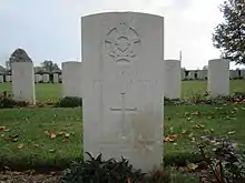 Colour photo of a grey gravestone marked with the Royal Australian Air Force crest and details of Pilot Officer F.J. Knight. Several rows of other evenly spaced gravestones are visible behind it.