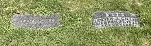 Two small gravestones recessed into the grass
