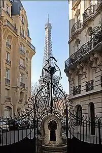 Exterior grill and fountain of 3 Square Rapp, with Eiffel Tower behind