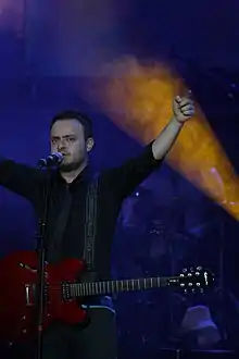Tuna Velibaşoğlu performing with Seksendört on stage