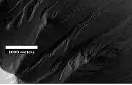 Gullies in Ross Crater, as seen by HiRISE under the HiWish program.  Because the gullies are on the narrow rim of a crater and they start at different heights, this example is not consistent with the model of gullies being caused by aquifers.