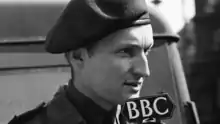 Headshot of a man in military-style uniform in front of a BBC microphone