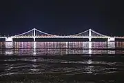 The bridge from the beach, illuminated at night (2018)