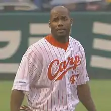 Alex Ochoa wearing a white and red pinstriped baseball uniform with "Carp" across the chest in red script