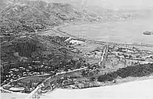 A large village in a mountain pass with roads leading through it