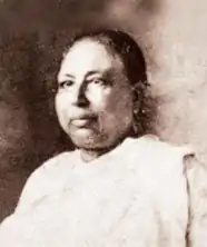 An older South Asian woman, wearing a sari.