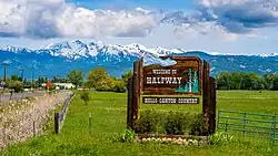 Welcome sign to the city of Halfway, Oregon. In the background are the Wallowa Mountains.