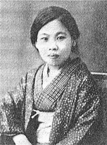 A young Japanese woman wearing a print kimono, seated
