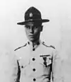 Top half of man in 1920s tropical U.S. Marine uniform with flat-brimmed campaign hat.