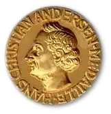 A golden medallion with an embossed image featuring a bust of Andersen.