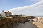 The precarious position of houses due to the effects of coastal erosion