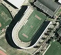 Aerial view of Harvard Stadium in Boston, in the form of a letter U with a capital H in the center of the field and the words Harvard and Crimson at either end