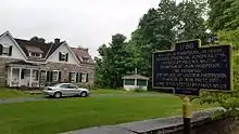 a picture of the marker, the large stone house behind it