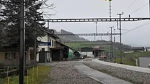 Single-story building next to platform and single-tracked railway line