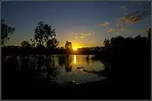 Peter Neaum (n.d.) Silhouette colour photograph of sunrise over the reflecting waters of Lake Mournpall, surrounded by low scrub, Hattah-Kulkyne National Park.