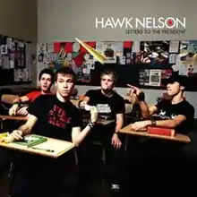 All of the band's members sitting in desks in a classroom setting