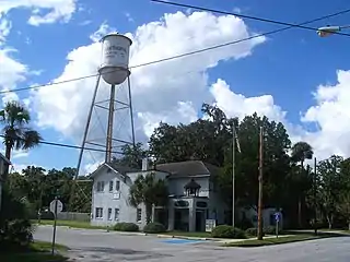 Two-story corner building with a water tower behind it