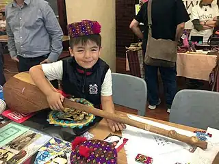 Hazara boy in  cultural clothing with a dambura
