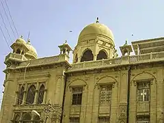 The building has domes and faux-minarets that are Mughal in style