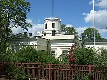 An astronomical observatory surrounded by greenery and trees.