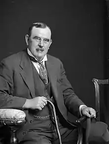 formal seated portrait of a man with a moustache