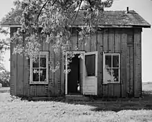 Herbert M. Fox House in Minnesota is a vertical plank wall house and is missing one of the structural planks which shows the interior lath and plaster. Photo credit: Library of Congress, Prints & Photographs Division, MINN,71-SAGO,1-3