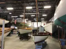 A large hanger full of a variety of Herreshoff designed sailing boats.