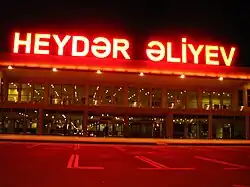  Two-storey building with a concrete-and-glass façade with a large neon sign reading "Heydər Əliyev" on the roof
