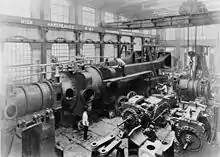 Under assembly c.1890, half of one of the two 10,000 hp engines completed for Deptford Power Station at Hick, Hargreaves and Co. A travelling crane and hoist above.