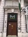 The Nigerian flag and coat of arms above the entrance