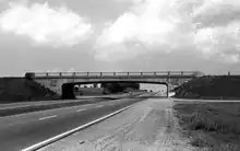 Black and white image of a bridge crossing a highway