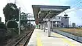 A view of the platforms and tracks. Note the station on the bridge spanning the tracks. There are entrances to the left and right.