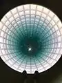 Hollow Earth by Glenn Kaino is an illuminated, glass-covered hole that creates the illusion of a tunnel descending deep into the Earth