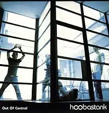 The cover features the band inside a glass room with bright lights behind them.