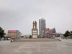 A monument depicting Kurban Tulum shaking hands with Mao Zedong stands in the centre of Tuanjie Square.
