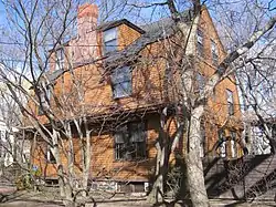 view of colonial revival three story house with trees