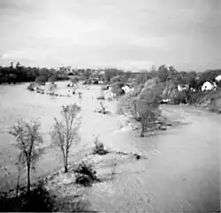 A generally flat area is completely submerged by water; trees are scattered throughout.