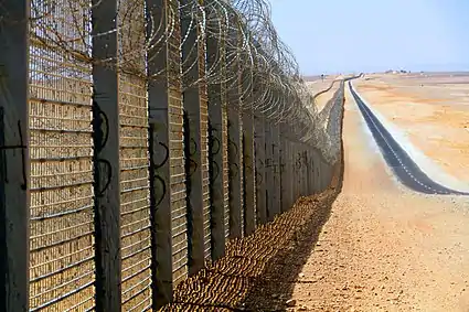 Image 9A more recent section of the Israel-Egypt barrier fence, north of Eilat, June 2012. It is a  border barrier built by Israel along its border with Egypt. It was originally an attempt to curb illegal migrants from African countries. Construction was approved on 12 January 2010 and began on 22 November 2010.