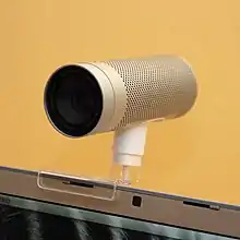 Cylindrical metal camera mounted on a laptop