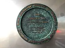 a cast bronze plaque architecture award fixed to a wall at the museum