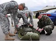 Soldiers with the Illinois Army National Guard and a Polish Soldier conduct medical response and litter use on a simulated casualty