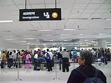 Immigration line at the IGIA. You can see the back of a person's head near the camera and further back you can see the line tethers which establish the line for immigration clearance in the airport