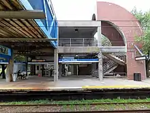 A brick and concrete structure supporting a footbridge at a railway station