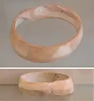 Indus bracelet, front and back, made of Fasciolaria Trapezium or Xandus Pyrum imported to Susa in 2600-1700 BCE. Found in the tell of the Susa acropolis. Louvre Museum, reference Sb 14473. This type of bracelet was manufactured in Mohenjo-daro, Lothal and Balakot. The back is engraved with an oblong chevron design which is typical of shell bangles of the Indus Civilization.