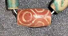 A rare etched carnelian bead found in Egypt, thought to have been imported from the Indus Valley civilization through Mesopotamia. Late Middle Kingdom. London, Petrie Museum of Egyptian Archaeology, ref. UC30334.