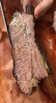 Inside of a beef rib cooked on a smoker grill
