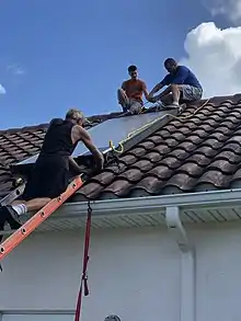 A team from Florida Solar East Installs a Solar System on a Sunny day Using a Ladder